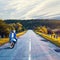 Old vintage blue scooter on the background of the road receding into the distance. Beautiful landscape. Cloudy sky