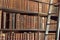 Old vintage books on wood bookshelf and ladder in a library