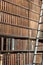 Old vintage books on wood bookshelf and ladder in a library