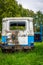 Old vintage car blue lush green grass broken glass