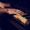 Old vintage classical black piano with male hand playing on it i