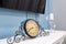 Old vintage clock on a fireplace shelf in a rich interior with a candlestick