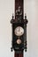 Old vintage grandfather wooden wall clock hanging on wood pillar