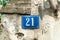 Old vintage house address metal plate number 21 twenty-one on the plaster facade of abandoned home exterior wall on the street s