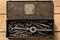 Old vintage iron toolbox full of drills and threading die tools on a wooden background