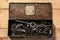 Old vintage iron toolbox full of drills and threading die tools on a wooden background