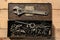 Old vintage iron toolbox full of drills and threading die tools on a wooden background