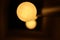 Old vintage lamp with three glowing light bulbs surrounded by darkness