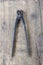 Old vintage pliers pincers against. wooden plank.