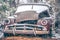 Old vintage plymouth automobile in the woods covered in snow