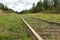 Old vintage railroad with wooden sleepers overgrown with grass