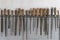 Old vintage rasps with wooden handles hanging on steel wall as background. A set of files and rasps for hand sanding, closeup.