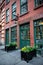 Old vintage red bricks commercial building with restaurant inside and green wooden doors.