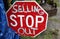 Old Vintage Road Stop Sign at an Antique Show Someone Added Words to say Stop Selling Out