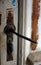 Old, vintage rusty door handle on an aged white door.