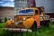 Old vintage scrapped truck in front of a red barn