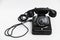 Old vintage stationary black telephone with dial and a tube