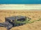 Old vintage suitcase for travel and family vacations lies on the beach. Sea shore ocean. Photo in a trendy retro style