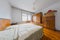 Old vintage wooden bedroom in an old house. Visible old bed, wardrobe closets and small bedside cabinets