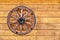 Old wagon wheel on a wooden wall