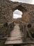 The old wall built of rocks and bricks with a window in the middle.