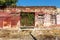 Old wall of destroyed house. Old powder wall with walled window and gates, doors. Ruined house. Remains of old houses. Apocalypse