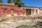 Old wall of destroyed house. Old powder wall with walled window and gates, doors. Ruined house. Remains of old houses. Apocalypse