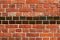 Old wall made of red ceramic bricks and glazed bricks.