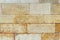 An old wall piled of stone yellow blocks. Natural background for design or texture