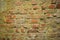 Old wall of red brick with crumbled plaster
