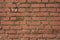 Old wall reddish bricks as a horizontal texture outside a building.