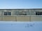 Old warehouse. Fence and old warehouse assignment. Industrial zone. Icicles on the roof