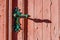 old weather-beaten red door with old vintage door knob, surface with chapped textured paint