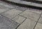 Old weather stained paving patio background with steps and bricks