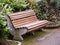 Old weathered bench in a garden park made with wood and concrete base. Comfortable sitting area