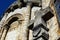 Old and weathered christian stone cross with 1643 inscription with church in background