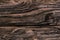 Old weathered dark brown cracked wooden knotted boards close-up