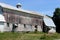 Old, weathered gray exterior wall of dairy barn seen out in the rural countryside