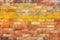 Old and weathered grungy yellow and red brick wall as seamless pattern texture background