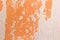 Old weathered painted wall background texture. orange dirty peeled plaster wall with falling off flakes of paint