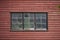 Old weathered rustic and dirty windows in in an old red painted wooden building. Close-up image