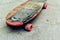 Old weathered skateboard on concrete surface