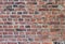 Old weathered stained red brick wall