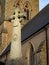 Old weathered stone cross in front of a church in England