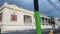 Old weathered white building in Puerto Rico with utility pole with green paint