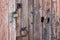 Old and weathered wooden door with a metal doorknob and a lock