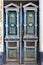 Old weathered wooden entrance doors with carved elements and a symmetrical pattern at the entrance of an old house