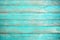 Old weathered wooden plank painted in turquoise or blue sea color.