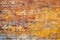 Old and weathered yellow and red brick wall, seamless pattern backdrop.