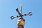 Old weathervane against a blue sky
